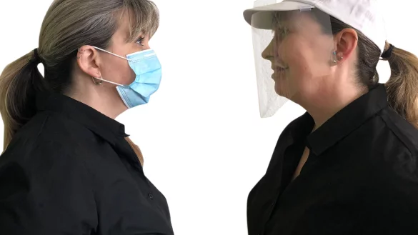 Maren Brettmeier, Marketing-Mitarbeiterin von POS Tuning, tr&auml;gt links einen textilen Mund-Nasen-Schutz und rechts ein Visier, das das Salzufler Unternehmen hergestellt hat. Fotorechte: Maren Brettmeier - &copy; Maren Brettmeier