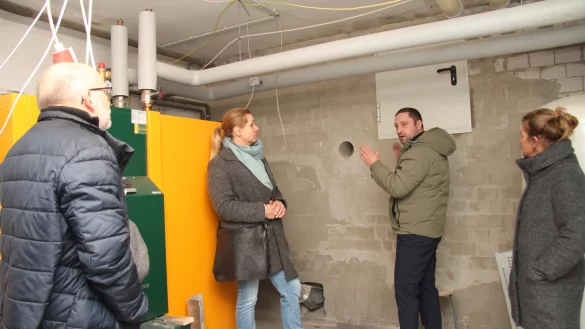SPD-Politiker Manfred Rehse (von links), Bauamtsleiterin Ewa Hermann, Bauleiter Nikolai Stoll und Schulleiterin Irina Müller stehen im Heizungsraum. Hinter der Wand befindet sich das Holzpellet-Lager. - © Nadine Uphoff