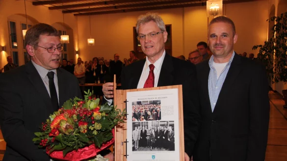 Geschenk zum Abschied: Die stellvertretenden B&uuml;rgermeister Frank Kuhlmann (links) und Heinz-Dieter Kr&uuml;ger (rechts) &uuml;berreichen Eberhard Block im Rathaussaal einen Fotoband mit vielen gesammelten Bildern aus dessen Amtszeit. - &copy; Cordula Gr&ouml;ne
