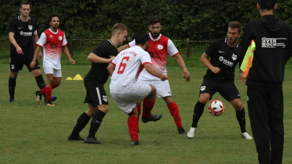 Horns Trainer Thorsten Schmiech h&auml;lt sich an der Fahne fest, w&auml;hrend (von links) Jerxens Kapit&auml;n Fabian Meier (von links), sein Gegenspieler Mikail &Uuml;nal sowie Hendrik Laabs, Enes Ulun, Onur &Uuml;nal und Kim Leonhard Eichhorst um den Ball k&auml;mpfen. - &copy; Dietmar Welle