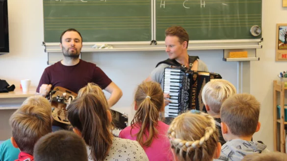 Johannes Geworkian Hellmann (links) und Lars Emil &Ouml;jeberget, alias "Symbio", spielen den zweiten Klassen der Grundschule Hardissen etwas vor. - &copy; Nadine Uphoff