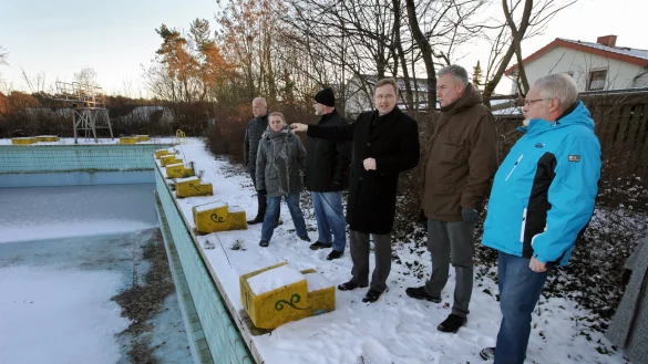 Nah dran: Bürgermeister Dr. Andreas Wulf erläutert beim Rundgang mit Bürgern kritische Punkte des Augustdorfer Freibads. Im Hintergrund ist links der Sprungturm, rechts die nahe angrenzende Wohnbebauung zu sehen. - © Bernhard Preuss