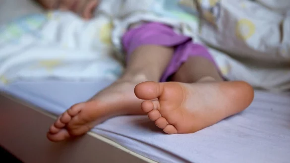 Kinderf&uuml;&szlig;e gucken unter einer Decke vor - &copy; Foto: Silvia Marks/dpa-tmn