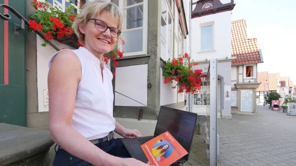 Die kommissarische VHS-Leiterin Claudia Biehahn klickt sich durch das neue Semesterprogramm der Volkshochschule Detmold-Lemgo, was erstmals nur online vorliegt. Darauf weist an den üblichen Auslagestellen ein orangefarbenes Kärtchen hin. - © Jost Wolf