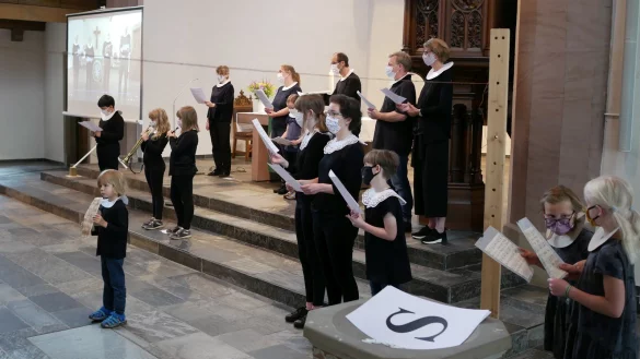 B: Sonntags eine Kantate. Der Kinderchor inszeniert mit Mundschutz die Kantate &bdquo;Jesu bleibet meine Freude" unter Leitung von Kantor Christoph Kuppler (hinten rechts). - &copy; Thomas Kr&uuml;gler