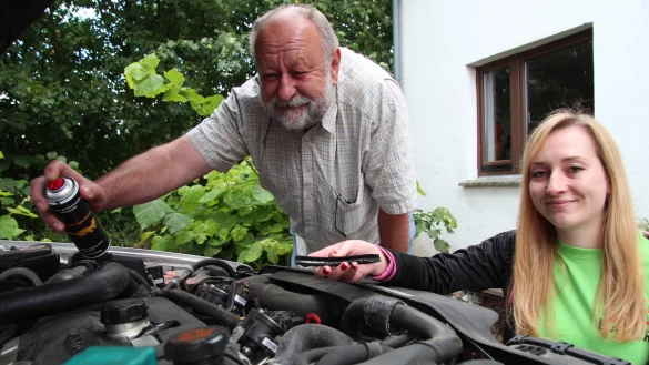 Sch&auml;dlingsbek&auml;mpfer Horst Bauer setzt sein Marderspray im Motorraum ein, seine Tochter und Juniorchefin in spe, Lisa Bauer, zeigt den Schaden. - &copy; Till Brand
