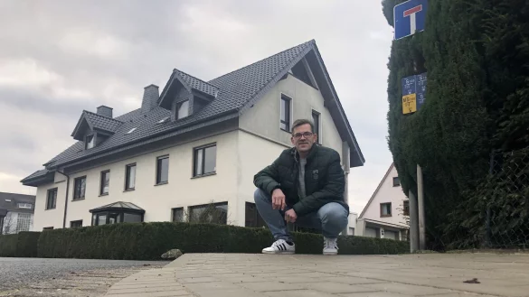 Andr&eacute; Schielmann kniet an einem abgesenkten Bordstein am Sperlingsweg, f&uuml;r den er sich eingesetzt hatte.&nbsp; - &copy; Sven Kienscherf