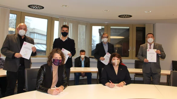 Die Gr&uuml;nen links, die Sozialdemokraten rechts: Fraktionsvorsitzender Werner Loke und Kreis-Parteisprecher Robin Wagener stehen hinter Kreissprecherin Dr. Inga Kretzschmar (vorne links), f&uuml;r die SPD unterschreibt die Kreisvorsitzende Ellen Stock. Hinter ihr stehen Fraktionsvorsitzender Henning Welslau und Landrat Dr. Axel Lehmann. Andreas Kuhlmann (SPD) unterzeichnet den Koalitionsvertrag als Mitglied der Landesverbandsversammlung. - &copy; Astrid Sewing