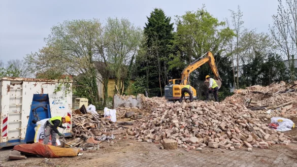 Der Bagger zieht die &Uuml;berreste des Hauses auseinander, w&auml;hrend die Arbeiter das Material sortieren. - &copy; Nadine Uphoff