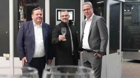 Jens-Uwe Göke (v.l.), Steven Heinemann und Robert Tönnies vor ihrer neuen UV-Siebdruckmaschine bei Ritzenhoff in Marsberg. - © Jemima Wittig