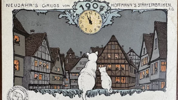 Zwei Katzen blicken hier auf die Stadt, dar&uuml;ber zeigt eine Uhr den bevorstehenden Jahreswechsel an. Logisch - die Karte spielt auf das Logo der Hoffmann&rsquo;s St&auml;rkefabriken an - eine Katze. - &copy; Sven Kienscherf