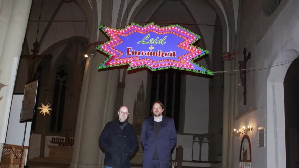 Der Lichtkünstler Jan Philip Scheibe (rechts) stellte mit Pfarrer Matthias Altevogt in der Kirche St. Marien Besuchern die Lichtinstallation „Leid und Einsamkeit“ vor. - © Juliana Szabo