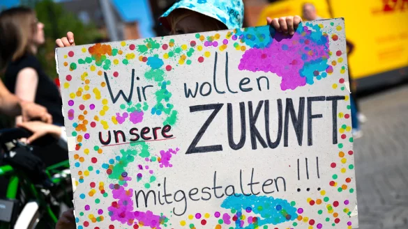 Ein Jugendlicher hält bei einer Demonstration ein Plakat mit der Aufschrift "Wir wollen unsere Zukunft mitgestalten!" - © picture alliance/dpa