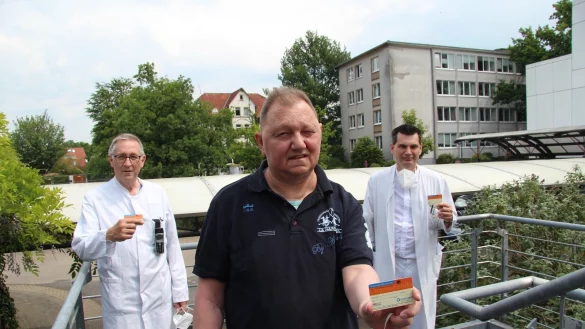 Organspender Axel M&ouml;ller aus Detmold (Mitte) zeigt einen Spendeausweis und wirbt f&uuml;r die Organspende. Er wird flankiert von Dr. J&uuml;rgen G&ouml;tz (links) und Dr. Rainer H&ouml;gel (rechts). - &copy; Silke Buhrmester
