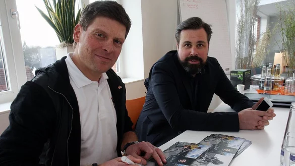 Unterschreibt Autogrammkarten: Jan Ullrich mit Manager Ole Ternes (r.).&nbsp; - &copy; Robert Becker