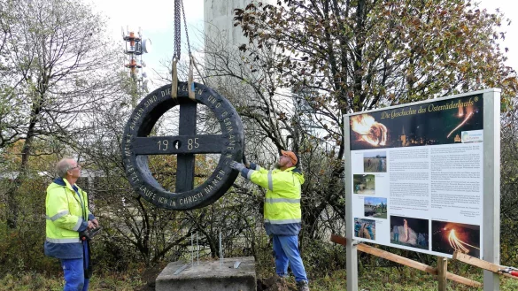 Mitarbeiter bugsieren das 250 Kilogramm schwere Eichenrad an seinen neuen Standort am K&ouml;terberg. - &copy; Achim Krause
