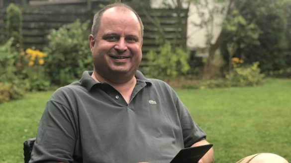 Arne Brand mit seinem Kindle im Garten, mit einem guten Science-Fiction-Roman kann er sich besch&auml;ftigen. - &copy; Till Brand