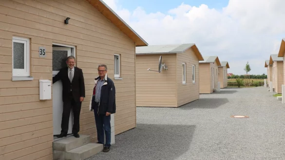 B&uuml;rgermeister Dr. Reiner Austermann (links) und Frank Laukamp zeigen die Holzh&auml;user f&uuml;r Fl&uuml;chtlinge. - &copy; Guntmar Wolff