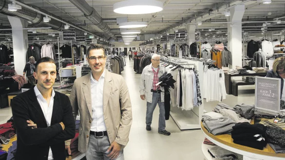 Wandlungsf&auml;hig: Unternehmenssprecher Sebastian Geist (l.) und Outlet-Leiter Thorsten Gr&ouml;ne in den umgestalteten und vergr&ouml;&szlig;erten Verkaufsr&auml;umen im "Kleinen Felde". Zw&ouml;lf dieser Center betreibt der bekannte Bekleidungshersteller im In- und Ausland. - &copy; Peter Steinert