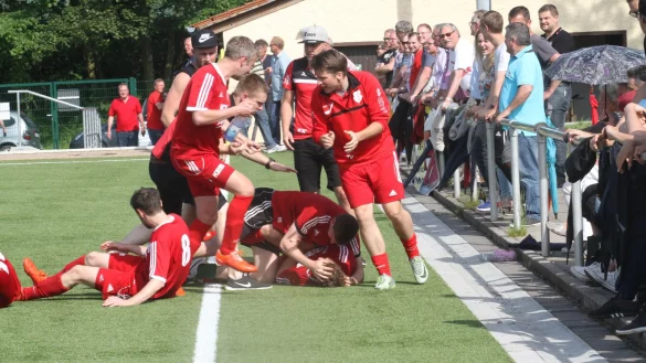 Schier erdrückt: Nach dem alles entscheidenden Treffer nimmt Torschütze Leon Baumeister auf dem Rücken liegend die herzlichsten Glückwünsche seiner Mannschaftskameraden entgegen. Auch die treuen RSV-Fans haben ihren Spaß. - © Dieter Welle