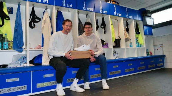 Tim Grothaus (links) und Samuel Zehnder „feiern“ in der TBV-Kabine die neue Partnerschaft mit Kempa. - © Jörg Hagemann