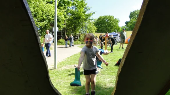 Carla-Elisabeth (4) wirft den Schuh pr&auml;zise durch die ausgestanzte Form beim "Gummistiefel-Zielwurf". - &copy; Hajo G&auml;rtner