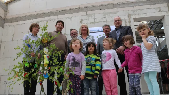 Mit Richtschmuck: (von links) Erzieherin Anette Cramer, Ratsmitglied Christian Kühnel (SPD), Siegfried Gehrke (AWO), Leiterin Brigitte Gerbach, Bürgermeister Gerhard Schemmel, Klaus Dannhaus (AWO) und die Kinder der Tagesstätte sind in Feierlaune. - © Thomas Dohna
