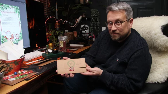 Sven Pontow zeigt einen fertigen Brief mit Siegel. Der nächste ist links auf seinem Monitor zu sehen. - © Jana Beckmann