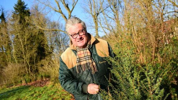 Friedhelm Begemann mit einem Wacholder. Die Pflanzen sind vielf&auml;ltig nutzbar. Sie bieten Tieren Schutz, sind gut f&uuml;r das &Ouml;kosystem und ihre Beeren sind nicht nur Grundlage f&uuml;r Schnaps, sondern auch als Gew&uuml;rz einsetzbar.&nbsp; - &copy; Nadine Uphoff