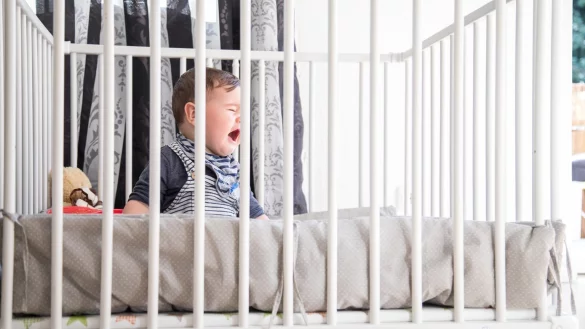Kind im Gitterbett - &copy; Foto: Christin Klose/dpa-tmn
