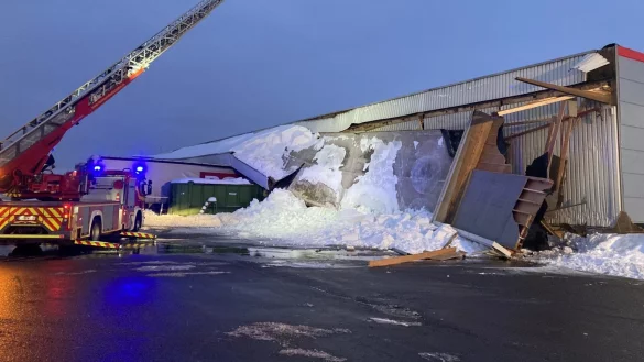Schneemassen haben das Vordach der Produktionshalle heruntergedr&uuml;ckt. &bdquo;Begraben" sind unter anderem zwei Lkw-Sattelauflieger. Die Holzbalken, die das Vordach st&uuml;tzten (wie beispielsweise rechts zu sehen), reichen in die eigentliche Halle herein und sind teilweise hochgedr&uuml;ckt worden.&nbsp; - &copy; Feuerwehr Bad Salzuflen