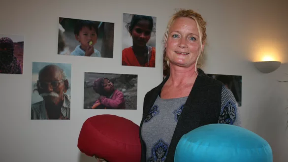 Das Gleichgewicht der Beziehungen im Blick: Martina Weiss symbolisiert Personen bei einer Aufstellung mit Yoga-Kissen. - © Sandra Castrup