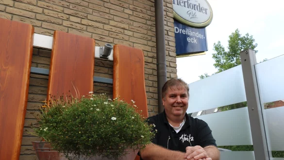 Joachim Kroos, genannt &bdquo;Apitz", sitzt in der Raucherecke seines Biergartens auf den urigen Holzb&auml;nken. - &copy; Alexandra Schaller