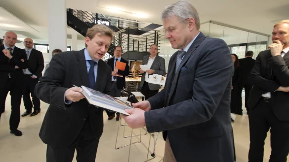 Pfarrer Thorsten Rosenau (links) zeigt NRW-Staatssekret&auml;r Dr. Heinrich Bottermann Fotos aus der Peterskirche. - &copy; Jens Rademacher