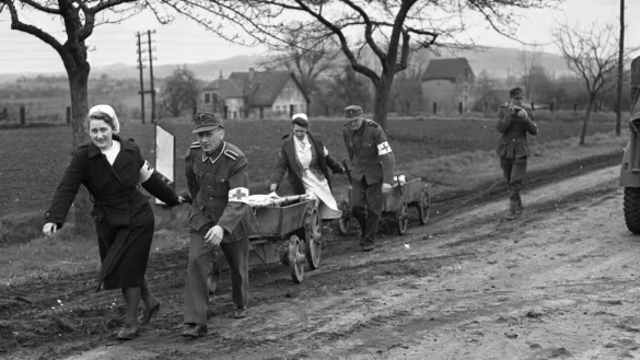 Deutsche Krankenschwestern und Sanitäter bergen am 4. April 1945 die deutschen gefallenen Soldaten vom Straßenrand. - © National Archives Washington D.C.