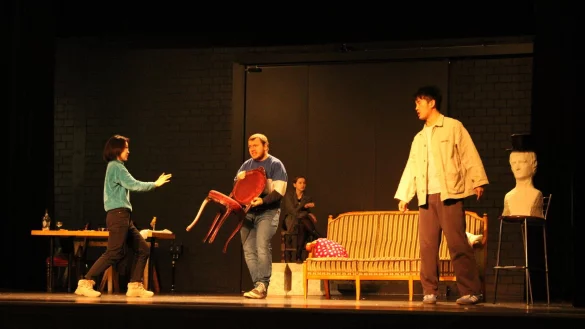 Mydas (Mitte, Jonas Domeier) versucht, sich vor dem eifersüchtigen Pygmalion (rechts, Zhanxiang Peng) und dessen Diener Ganymed (links, Ge Fang) zu schützen. Im Hintergrund ist die Statue Galathée (Kristina Sokova) zu sehen. - © Chiara Wibbeke