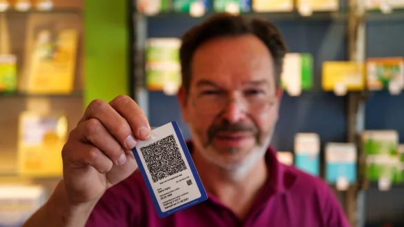 Oliver Müller, Inhaber der Bahnhof-Apotheke in Detmold, zeigt die Immunkarte. Wer seinen Impfnachweis gerne in Kartengröße bei sich tragen möchte, kann sich diese kostenpflichtig bei einigen Apotheken ausstellen lassen. - © Till Sadlowski