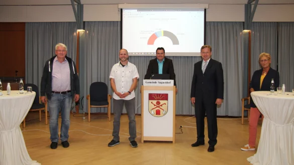 Thomas Katzer (links) und Dr. Andreas J. Wulf (2. von rechts) werden in zwei Wochen zur Stichwahl antreten. Martin Thiel (2. von links) und Carola Pla&szlig; erzielten Achtungserfolge. In der Mitte Wahlleiter Patrick Herrmann mit der Sitzverteilung im neuen Augustdorfer Rat. - &copy; Dieter Asbrock