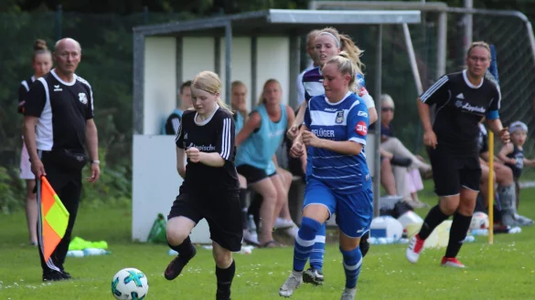 Dynamik: Als Linienrichter beobachtet Mario Reinhold die Szene, in der Donop-Voßheides Annalena Meier (links) gegen ihre Wiedenbrücker Gegenspielerin die Oberhand behält. Jana Wiemann-Großpietsch (rechts) behält die Szene im Auge. - © Kai Hahn