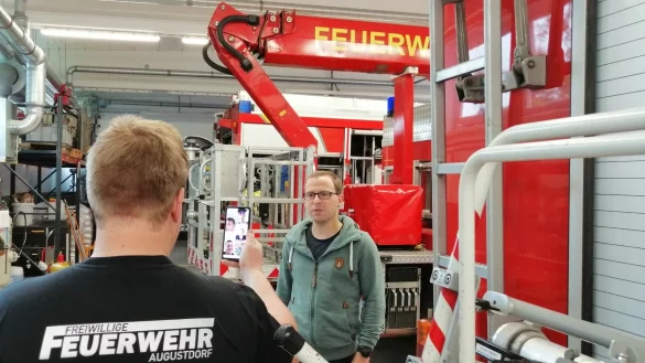 Die Augustdorfer Jugendfeuerwehr geht neue Wege. Fahrzeugkunde steht auf dem Stundenplan des ersten digitalen Dienstabends. Gemeindejugendfeuerwehrwart Christoph Diekmann (rechts) gibt die Erkl&auml;rungen, w&auml;hrend Jugendwart Carsten Hansmeier mit dem Smartphone filmt. - &copy; Feuerwehr Augustdorf