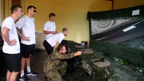 Oberstabsgefreiter Woldemar Sarkisjan zeigt (von links) Bobby Schagen, Isaias Guardiola, Jonathan Carlsbogard und Alexander Reimann im Gefechtssimulator den richtigen Umgang mit der P8-Pistole. - &copy; J&ouml;rg Hagemann