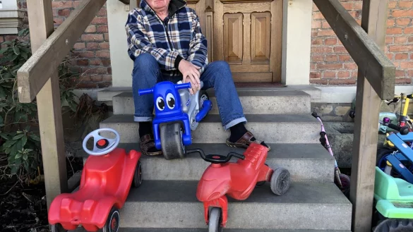 Tagesvater Udo Baumann sitzt auf der Treppe seines Hauses in Retzen und blickt nachdenklich in die Zukunft. Vor ihm stehen Spielgeräte, auf denen sonst die Kinder fahren, die er betreut. Zurzeit bricht ihm ein Großteil seiner Einnahmen weg. Foto: Sven Kienscherf - © Sven Kienscherf