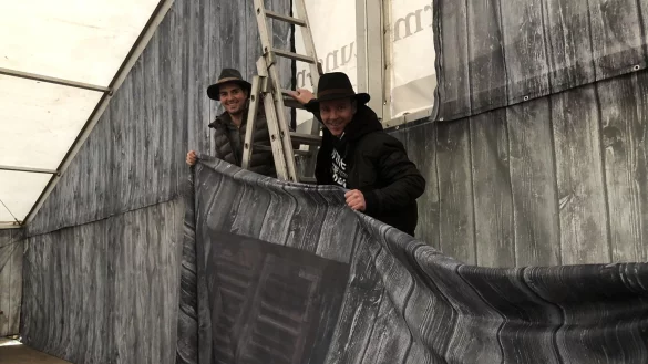 Der Aufbau zur M&uuml;hlengaudi am Schloss Brake l&auml;uft auf Hochtouren. Dustin Cord (links) und Michael Nolting h&auml;ngen die Banner auf, die mit Holzoptik f&uuml;rs H&uuml;ttenflair im Festzelt sorgen sollen.&nbsp; - &copy; Till Brand