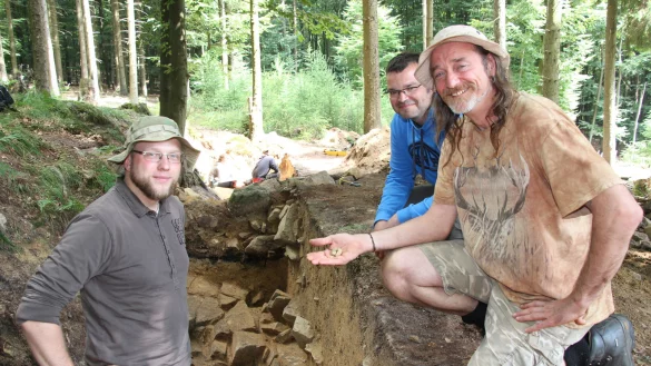 Funde im Wald: (von links) Johannes M&uuml;ller-Kissing mit den Experten der Cardiff University, Dr. Oliver Davis und Ian Dennis, Dozent f&uuml;r Grabungstechnik und Fundbearbeitung. Sie zeigen den Spinnwirtel, der auf der Fl&auml;che gefunden wurde. - &copy; Marlen Grote