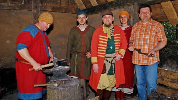 Leiter Roeland Paardekooper (rechts) in der Schmiede mit Sebastian von Nagaroon, Daniel Naguschewski, Andreas Geisb&uuml;sch und Xenia Stiewe (von links), die die h&auml;usliche Arbeit des Fr&uuml;hmittelalters naturgetreu nachstellen. - &copy; Held