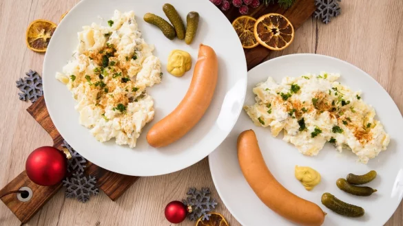 Zwei Teller mit W&uuml;rstchen und Kartoffelsalat. - &copy; Foto: Christin Klose/dpa-tmn