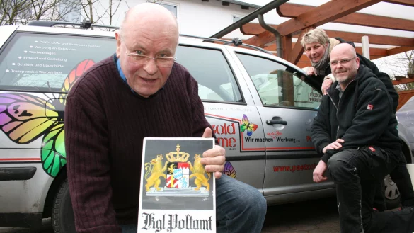 Tradition trifft Moderne: Siegfried Pätzold mit einer handbemalten Reklametafel. Sohn Stephan und dessen Frau Nicole (von links) haben sich auf Folienbeschriftungen an Fahrzeugen spezialisiert.