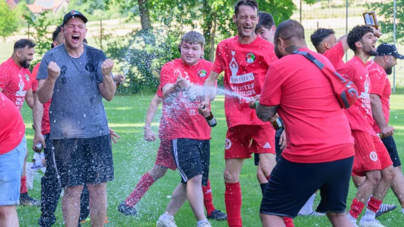 Henri Ellerbrok (links), Trainer des SV Wüsten, feiert nach dem Abpfiff mit seinem Team ausgelassen den Aufstieg in die Kreisliga A Lemgo. - © Egon Penner
