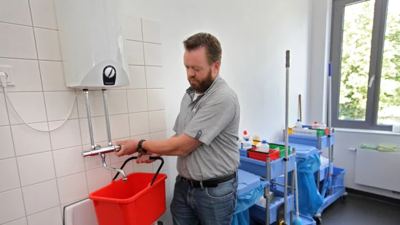 Die Quelle der Überflutung: Hätte die Putzfrau es so gemacht, wie Gebäudemanager Dirk Tappe es hier demonstriert, wäre nichts passiert. Aber sie hat das Wasser mit einem Schlauch in den auf einem Systemwagen stehenden Eimer gezapft. - © Foto: Bernhard Preuß