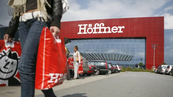 Eine Kundin l&auml;uft in Hamburg am M&ouml;belhaus H&ouml;ffner entlang. - &copy; picture-alliance/ dpa